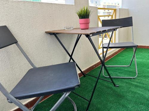 a table with two chairs and a potted plant on it at cosy2bedroomapartment in Loulé