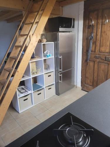 a kitchen with a staircase leading up to a refrigerator at Gîte avec piscine privatisée in Chamaret