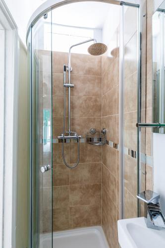 a shower with a glass door and a sink in a bathroom at Eden Cottage - 9 Guests, Sea Views, Central Cowes, Ferry Deal in Cowes