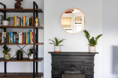 a mirror on a shelf next to a table with plants at Eden Cottage - 9 Guests, Sea Views, Central Cowes, Ferry Deal in Cowes