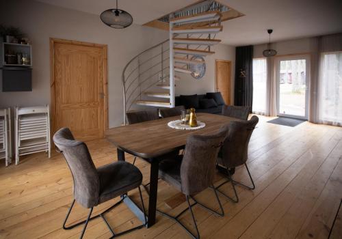 a dining room with a wooden table and chairs at Kempings Ozolkalns in Cēsis