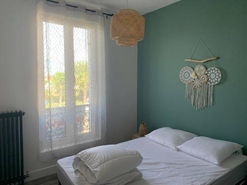 une chambre avec un lit blanc et une fenêtre dans l'établissement Appartement rénové à 200m de la plage, à Châtelaillon-Plage