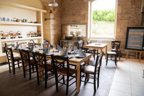 a dining room with a table and chairs at Le Moulin du Porteil in Campagne