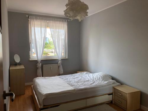 sypialnia z łóżkiem i oknem w obiekcie Bałtycki Chill - apartament z możliwością Home Office w mieście Gdynia