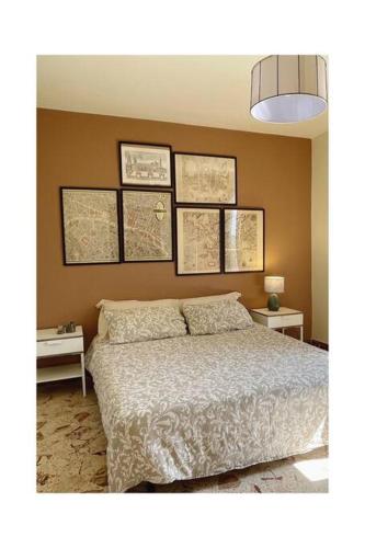 1 dormitorio con 1 cama y mapas en la pared en Bilocale Cicerone nel cuore di Gangi, en Gangi