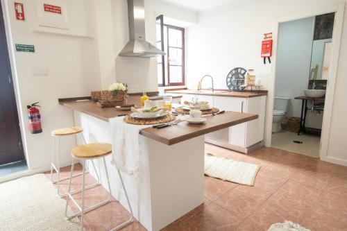 a kitchen with a island in the middle of a room at The Village House in Machico