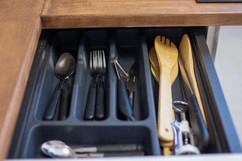 a drawer filled with utensils in a wooden drawer at The Village House in Machico