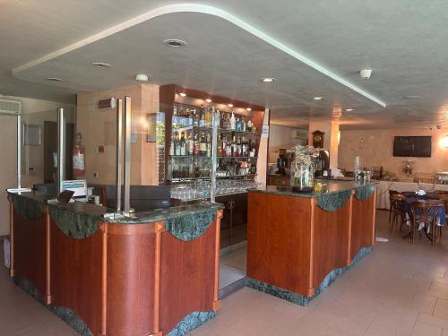 里米尼的住宿－Hotel Bel Sogno，餐厅内的酒吧配有桌椅
