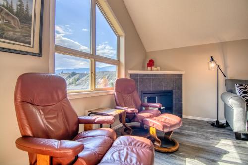 a living room with two chairs and a fireplace at Mountain getaway condo - 5 min walk to the beach! in Invermere