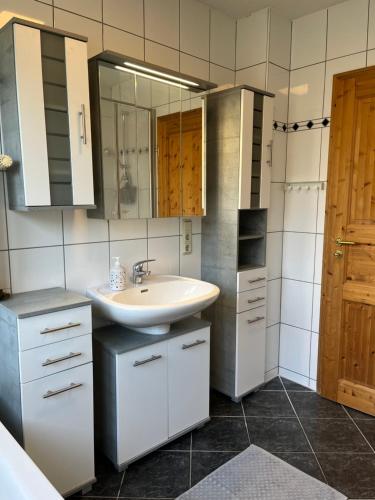 een badkamer met een wastafel en een spiegel bij Ferienhaus Beerennest in Butjadingen