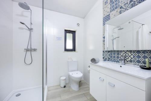 ein Bad mit einer Dusche, einem WC und einem Waschbecken in der Unterkunft CoolHouses Algarve, Luz, 3 Bed villa, 1 bed studio, heated pool & jacuzzi, sea views, Casa Pequena in Luz