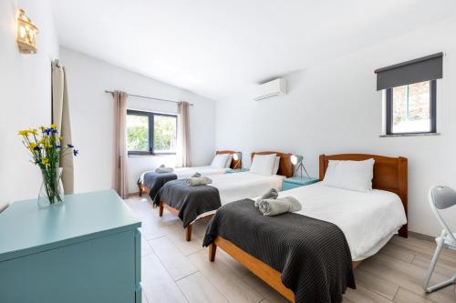 1 Schlafzimmer mit 2 Betten, einem Tisch und Stühlen in der Unterkunft CoolHouses Algarve, Luz, 3 Bed villa, 1 bed studio, heated pool & jacuzzi, sea views, Casa Pequena in Luz