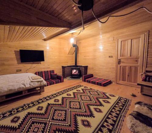 ein Schlafzimmer mit einem Kamin, einem Bett und einem Teppich in der Unterkunft Selin Yaşam Evi in Artvin