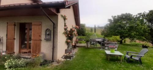 un jardín con mesa y sillas y una casa en ISA ET LIO en Chavanod