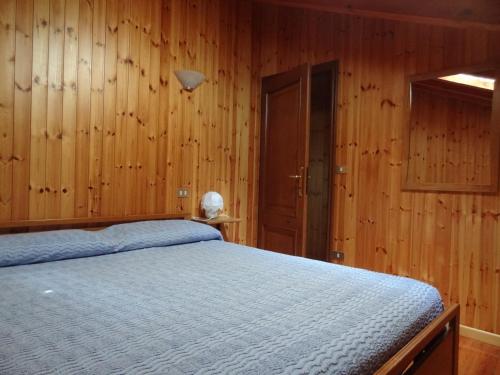 ブリュソンにあるSunlake Arcesazのベッドルーム1室(木製の壁とドアのベッド1台付)