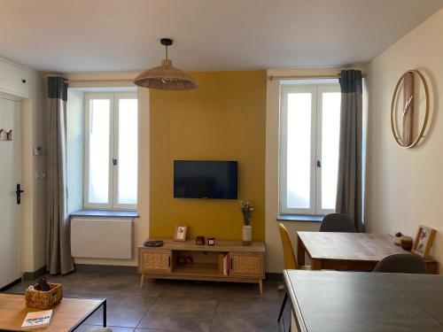 a living room with a tv and two windows at Exceptionnel ! Superbe appartement refait à neuf en rez-de-chaussée avec parking privé in Castres