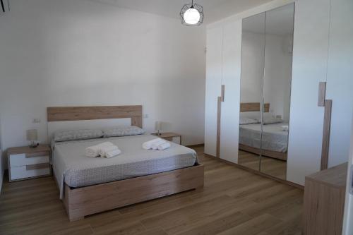 1 dormitorio con cama y espejo grande en le casette, en Aradeo