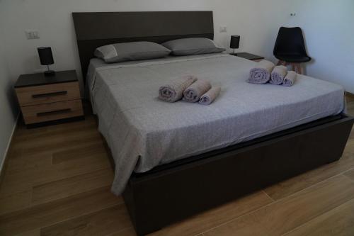 a bedroom with a bed with three towels on it at le casette in Aradeo