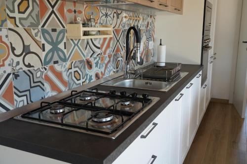 a kitchen with a sink and a stove top oven at le casette in Aradeo