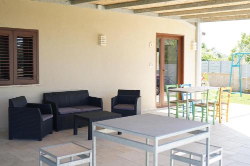 a patio with a table and chairs and a couch at le casette in Aradeo