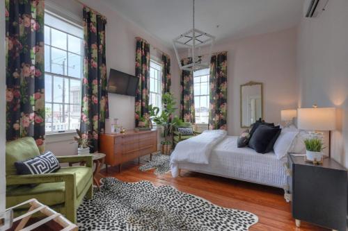a bedroom with a bed and a dresser and windows at Sugar's INN Room #6 King Bed in Galveston
