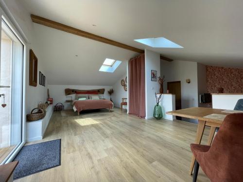 a large living room with a bed and a table at Le clos des grandes rivières in Sainte-Soulle
