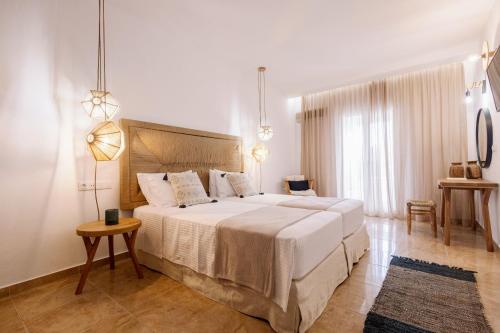 a bedroom with a large bed and a table at Ariadne Hotel in Agios Prokopios