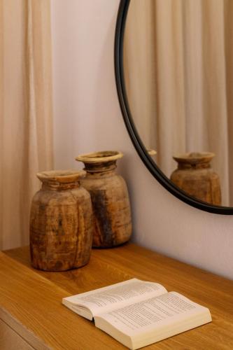 a table with three jars on a table with a mirror at Ariadne Hotel in Agios Prokopios
