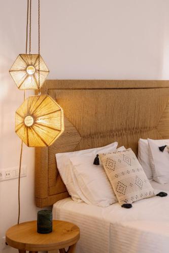 a bedroom with a bed with a table and a lamp at Ariadne Hotel in Agios Prokopios