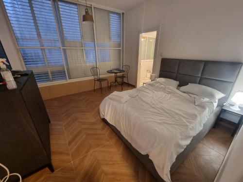 a bedroom with a large bed and a table and chairs at הברון baron in Rishon LeẔiyyon