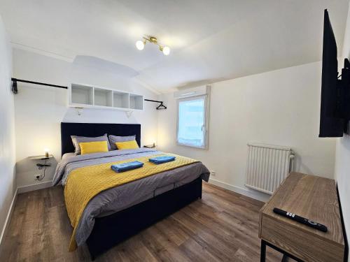 1 dormitorio con 1 cama con sábanas amarillas y ventana en Royal Terrace - Maison plage & Parking privé, en Dunkerque