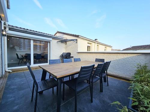 une table et des chaises en bois sur une terrasse dans l'établissement Royal Terrace - Maison plage & Parking privé, à Dunkerque