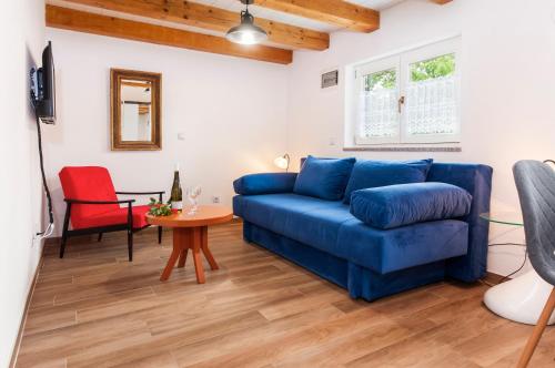 een woonkamer met een blauwe bank en een tafel bij STANZIA Santa Brigida in Rovinj