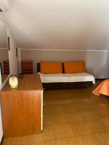 Zimmer mit einem Bett und einem Holztisch in der Unterkunft Casa panoramica in Mascali