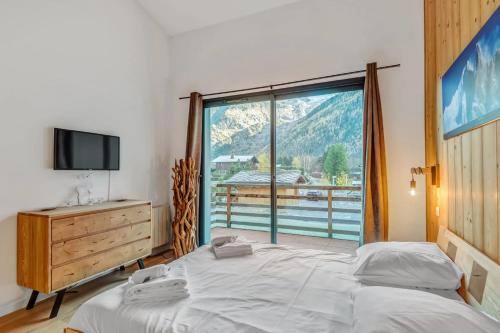 1 dormitorio con cama y ventana grande en Résidence Luxe 5*,Spa & Fitness, La Cordée Appartement 214, en Chamonix-Mont-Blanc