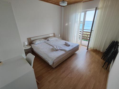 a bedroom with a bed with a view of the ocean at Apartment Padova I and II in Rab