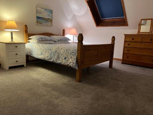 a bedroom with a bed and a dresser and a television at Lower Thura House in Wick