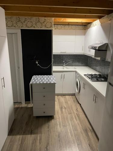 a kitchen with white cabinets and a sink and a stove at Cozy studio in town center 2 in Limassol