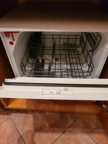 an open dishwasher with a stove top oven at Appartement Camp Terme Čatež P93 in Čatež ob Savi