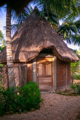 un pequeño edificio de ladrillo con techo de hierba en AFLII Guest house, en Mtwara