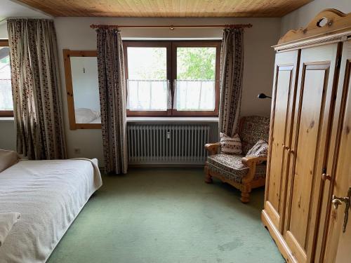 1 dormitorio con 1 cama, 1 silla y 1 ventana en Oberaudorf-Kaiserblick en Oberaudorf