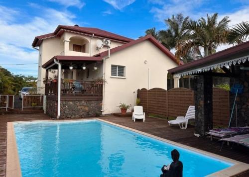 une villa avec une piscine en face d'une maison dans l'établissement Villa PANAM' chez R'Marine439 locations saisonnières, à Sainte-Rose
