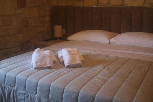 Una cama con dos toallas encima. en Villa Palma, en Kallithea Halkidikis