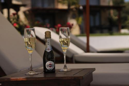butelkę szampana i dwa kieliszki na stole w obiekcie Villa Palma w mieście Kallithea