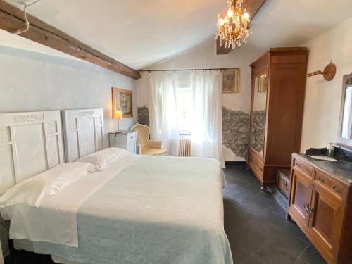 a bedroom with a large bed and a chandelier at AGRITURISMO CASA OLIVIERI in Sestri Levante