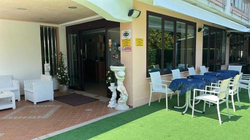 un restaurant avec une table bleue et des chaises blanches dans l'établissement Hotel Bel Sogno, à Rimini