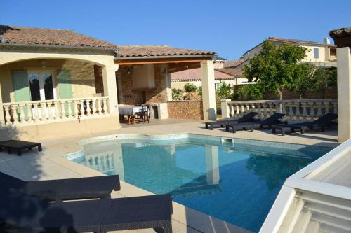 une piscine avec des chaises et une maison dans l'établissement Les fadas du Ventoux, à Sault