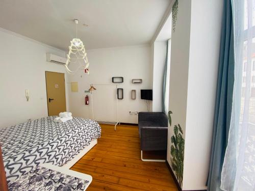 1 dormitorio con 1 cama y 1 silla en Porto City Centre Studios, en Oporto