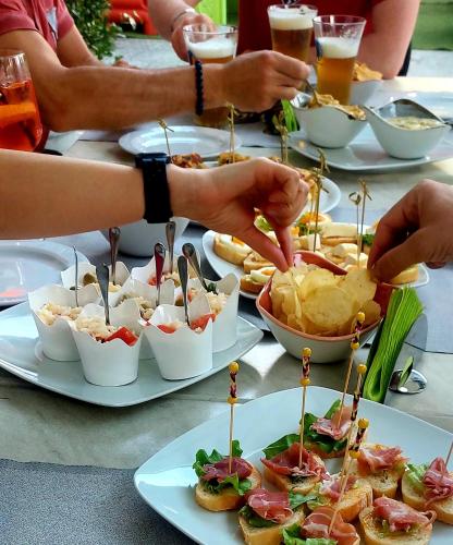 a table full of plates of food with chips and appetizers at Albergo Pesce D'oro in Verbania