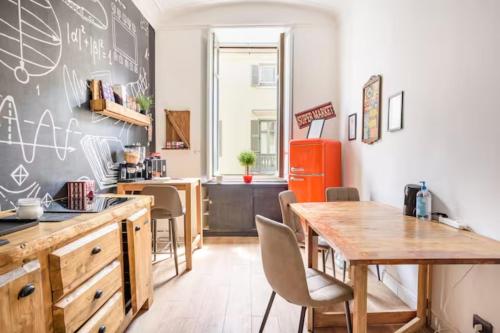 a kitchen with a table and a chalkboard wall at Apartments Chic Torino Centro porta nuova in Turin